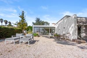 a metal building with chairs and tables in a yard at Villa Artemis piscine Golfe St-Trop in Grimaud