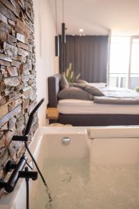 a bath tub in a room with a brick wall at Luxus Appartement mit Panoramablick in Sinsheim