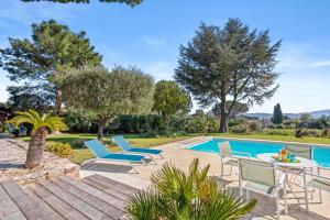 an outdoor patio with chairs and a swimming pool at Villa Artemis piscine Golfe St-Trop in Grimaud