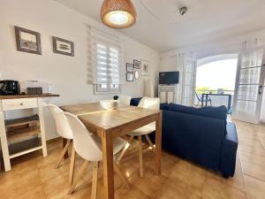 a living room with a table and a blue couch at White Sands 3.08 in Arenal d'en Castell