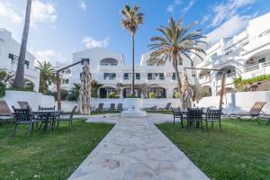 a patio with tables and chairs in front of a building at White Sands 3.08 in Arenal d'en Castell
