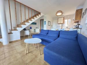 a living room with a blue couch and a table at White Sands 3.08 in Arenal d'en Castell