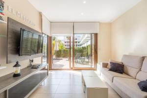 a living room with a couch and a tv at Terrazas de Campoamor Sunrise in Orihuela
