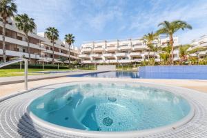 a large swimming pool with a large building in the background at Terrazas de Campoamor Sunrise in Orihuela