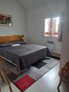 a bedroom with a bed and a window at Duplex Près Du Lac De La Raviège in La Salvetat