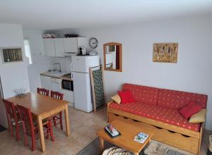 a living room with a couch and a table at Duplex Près Du Lac De La Raviège in La Salvetat
