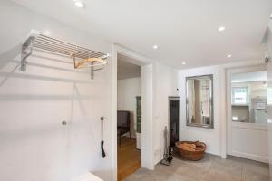 a white bathroom with a shower and a hallway at Ferienhaus Allgäuperle in Altusried +20 photos