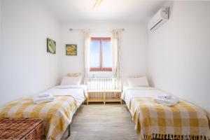 two beds in a room with a window at Casa Cala Santanyí in Santanyi +15 photos