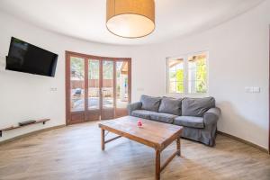 a living room with a couch and a coffee table at Casa Cala Santanyí in Santanyi