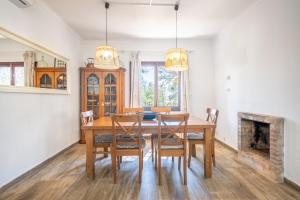 a dining room with a table and chairs and a fireplace at Casa Cala Santanyí in Santanyi