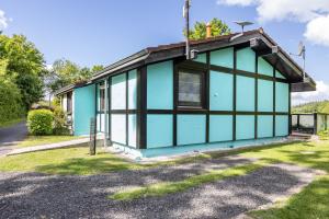 a blue house with black windows at Ferienhaus Sweet Home in Machtlos