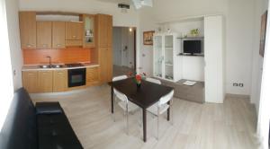 a living room with a table and a kitchen at Torre dell'orso centralissima vista mare in Torre dell'Orso