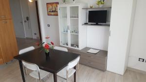 a dining room with a black table and white chairs at Torre dell'orso centralissima vista mare in Torre dell'Orso