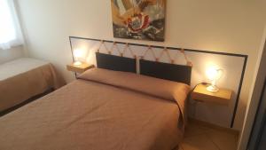 a bedroom with a bed with two lights on it at Torre dell'orso centralissima vista mare in Torre dell'Orso