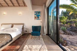 a bedroom with a bed and a blue chair at Villa Miramar in Puntagorda