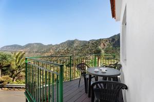 a table and chairs on a balcony with mountains at Casa de Berta in Vallehermoso