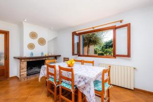 a dining room with a table and chairs and a fireplace at Sa Plana in Son Servera
