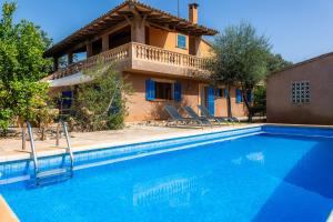 a villa with a swimming pool in front of a house at Sa Plana in Son Servera