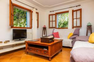 a living room with a couch and a tv at Sa Plana in Son Servera