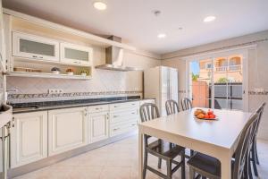 a kitchen with a table and a table and chairs at Casa las Bahias in Llucmajor