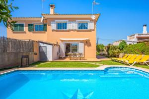 a villa with a swimming pool in front of a house at Casa las Bahias in Llucmajor