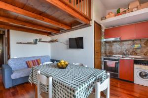 a kitchen and dining room with a table and a couch at Appartamento a Cavo sul mare in Cavo