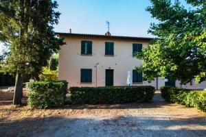 a large white house with green shutters at Podere Simonetta - A9 in Cecina