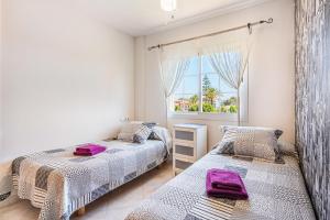 a bedroom with two beds and a window at Casa las Bahias in Llucmajor +17 photos