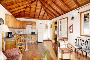 a kitchen and living room with a wooden ceiling at Casita Ariadna in Tijarafe