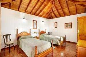 two beds in a room with a wooden ceiling at Casita Ariadna in Tijarafe