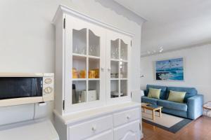 a white cabinet in a living room with a blue couch at Casa do Largo - Acores in Ponta Delgada