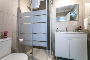 a white bathroom with a toilet and a sink at Oásis Fonte Grande in Santo António +36 photos