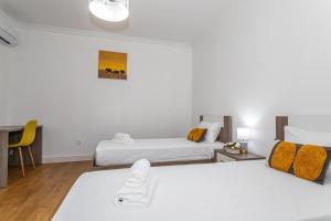 a hotel room with two beds and a desk at Oásis Fonte Grande in Santo António
