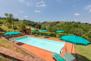 a swimming pool with chairs and umbrellas at Pietraserena - San Gimignano in San Gimignano