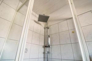 a shower with a fan in a bathroom at Ferienhaus Kron in Südbrookmerland +14 photos