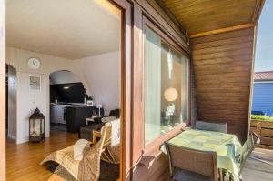 a room with a balcony with a table and chairs at Ferienhaus Kron in Südbrookmerland