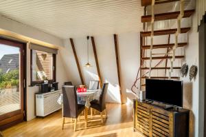 a dining room with a table and a television at Ferienhaus Kron in Südbrookmerland