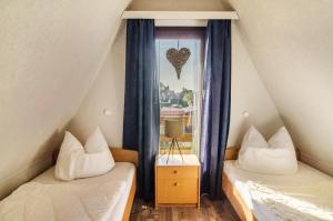 a bedroom with two beds and a window with a heart picture at Ferienhaus Kron in Südbrookmerland