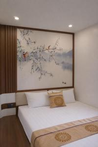 two beds in a room with a painting on the wall at V3K03 Sonasea Vân Đồn in Thâm Câu