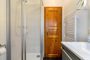 a bathroom with a shower and a wooden door at Ferienwohnungen Sterdebüll-Hof in Bordelum +120 photos