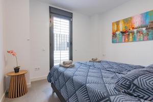 a bedroom with a bed with a blue and white comforter at Adhara - 034 in Torre del Mar +22 photos