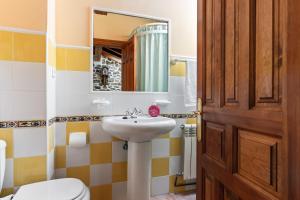 a bathroom with a sink and a toilet and a mirror at Casa El Campano in Ontaneda +21 photos
