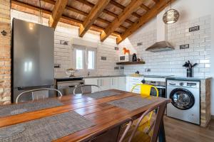 a kitchen with a wooden table and a refrigerator at Casa rural Maño in Deltebre