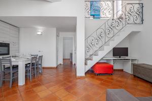 a dining room with a table and a staircase at Trilo Piazzetta Garden in San Teodoro
