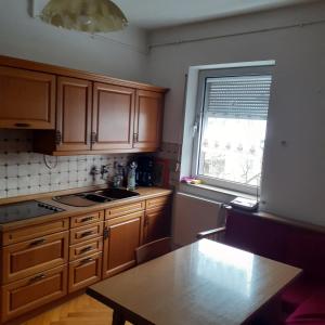 a kitchen with wooden cabinets and a table and a window at Backstubencafe Beck in Ansbach