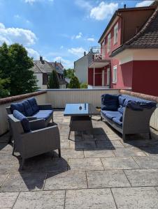 a patio with two couches and a table on a patio at Backstubencafe Beck in Ansbach