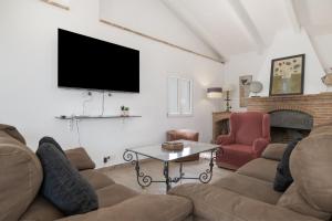 a living room with a couch and a tv at Finca El Porvenir in El Gastor