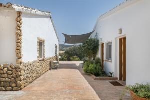 a courtyard of a house with a stone wall at Finca El Porvenir in El Gastor