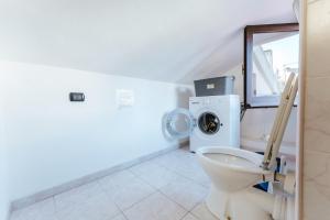 a bathroom with a toilet and a washing machine at Casa Vacanze Villa Carola in Quartu SantʼElena +15 photos