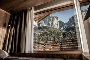 a bedroom with a window with a mountain view at Mysciliar Apartment Sky I in Siusi
